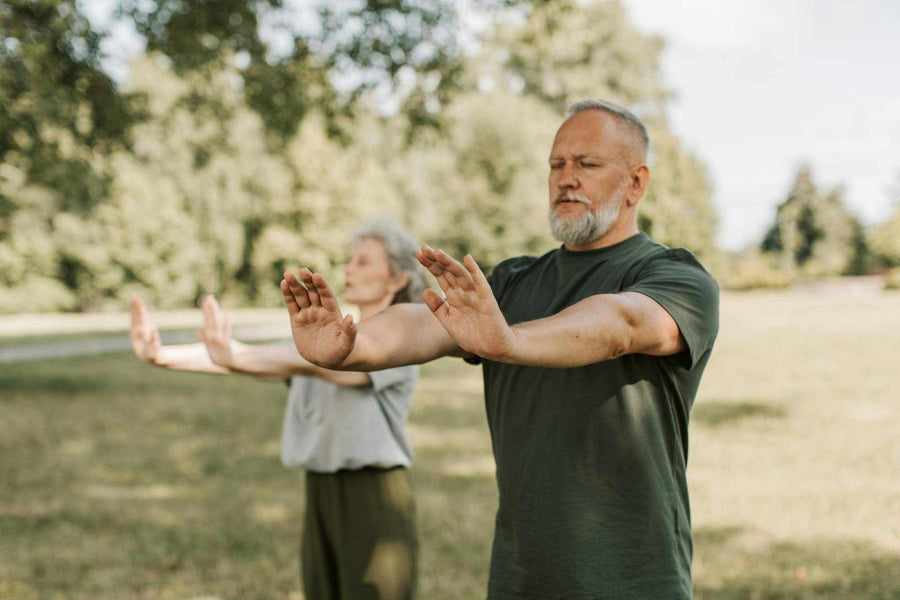 Elderly individuals practicing mindful relaxation outdoors, promoting health and vitality through NAD IV Therapy.