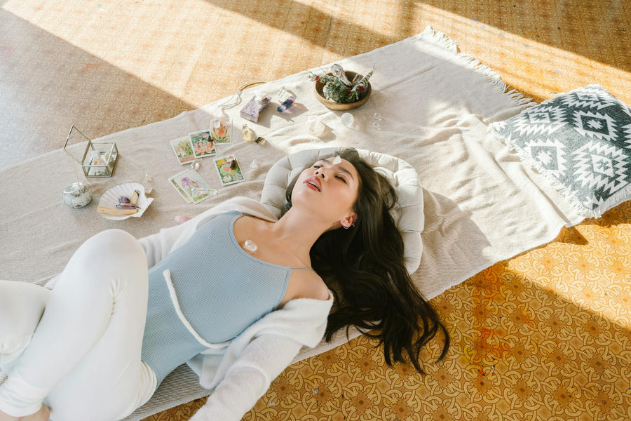 Relaxing woman with stones and cards on a mat, symbolizing tranquility of NAD IV therapy.